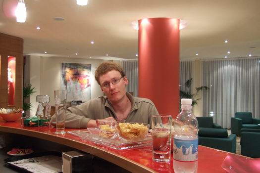 Me drinking a beer in a hotel somewhere outside Milan in Italy at 03.00 o'clock in the morning after a nightmare trip from Milan and back again. After a nice flight from Moscow to Milan I stepped onto the Alitalia Airbus 3-something thinking that I would be in Dakar approximately 5 hours later. That was a far-fetched idea because 15 minutes into the flight a very load sound appeared from around where the landing gear were. Shortly after the onboard pc screens showed that we were turning around and heading towards Milan again. The pilot a bit later told us coldly that we were experiencing problems with the hydraulics and the ground personal had to take look at it. He did not say that half of Milan Malpensa Airport's fire trucks were going to be in high alert with their lights turned on next to the runway when we were going to land.